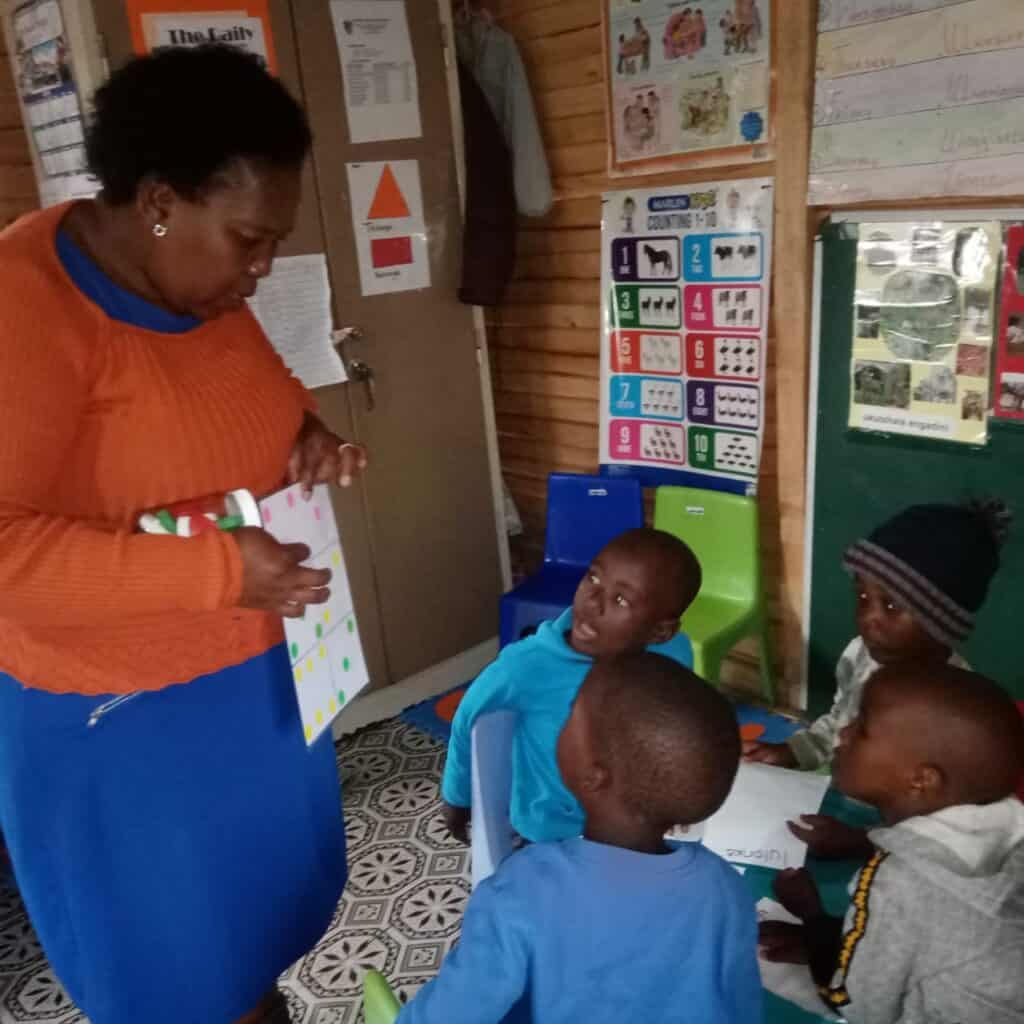 Teacher showing children a counting chart